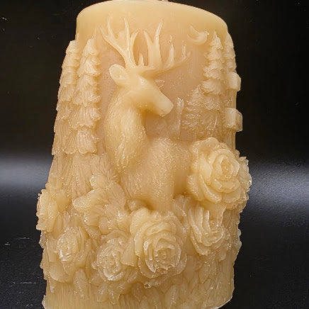 Decorative candle with deer and floral design on a black background