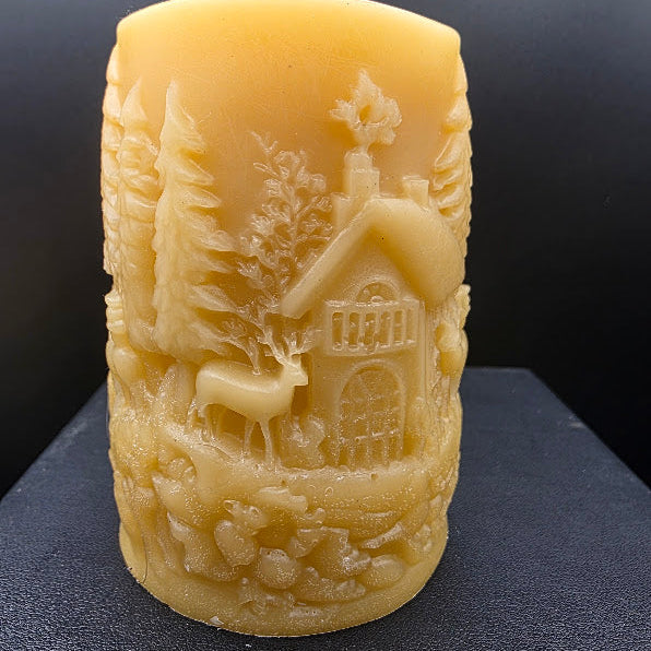 Beeswax candle with a landscape design on a dark background