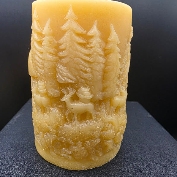 Beeswax candle with forest design on a black background