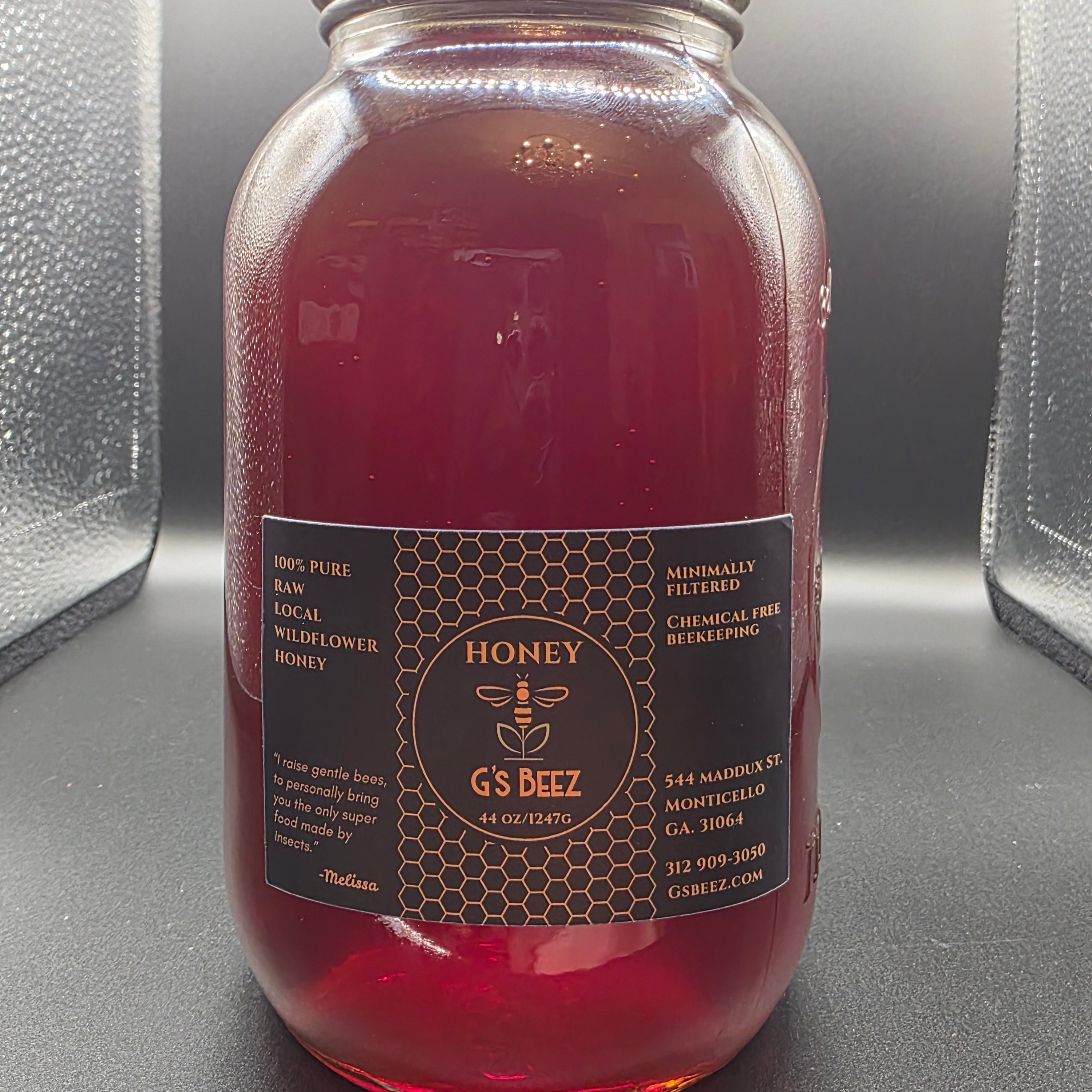 Bottle of honey with a label on a dark background
