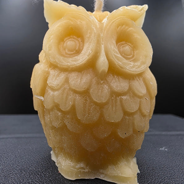 Beeswax owl candle on a dark background.