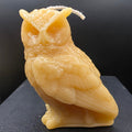 Owl-shaped candle on a dark surface