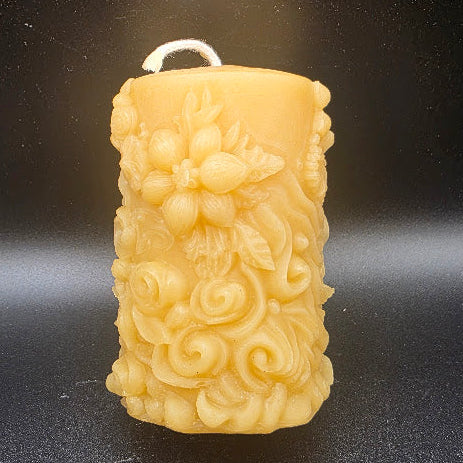 Decorative candle with intricate designs on a black background