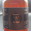 Bottle of honey with a label featuring the brand 'G's Beez' on a black background