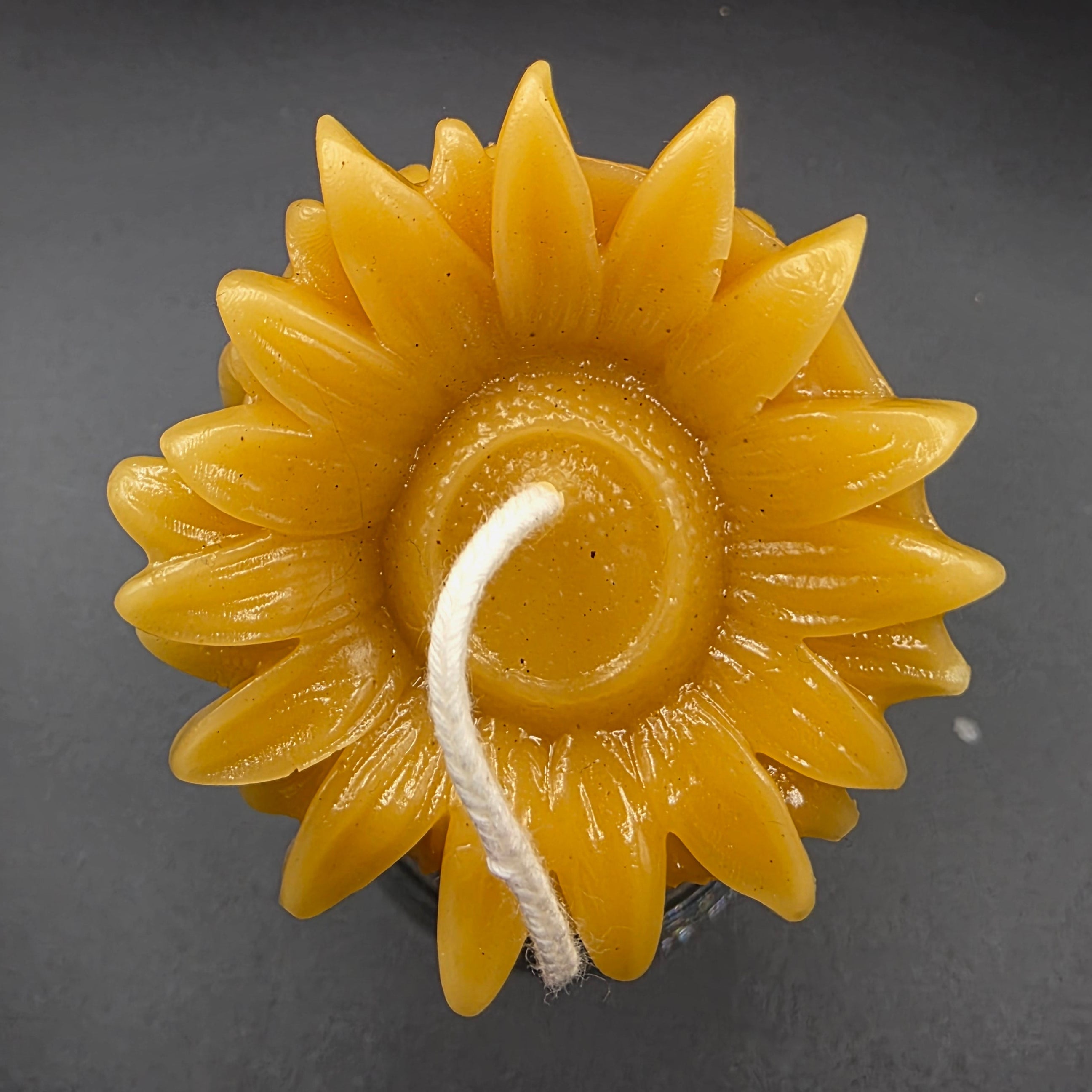 Sunflower-shaped candle on a dark background