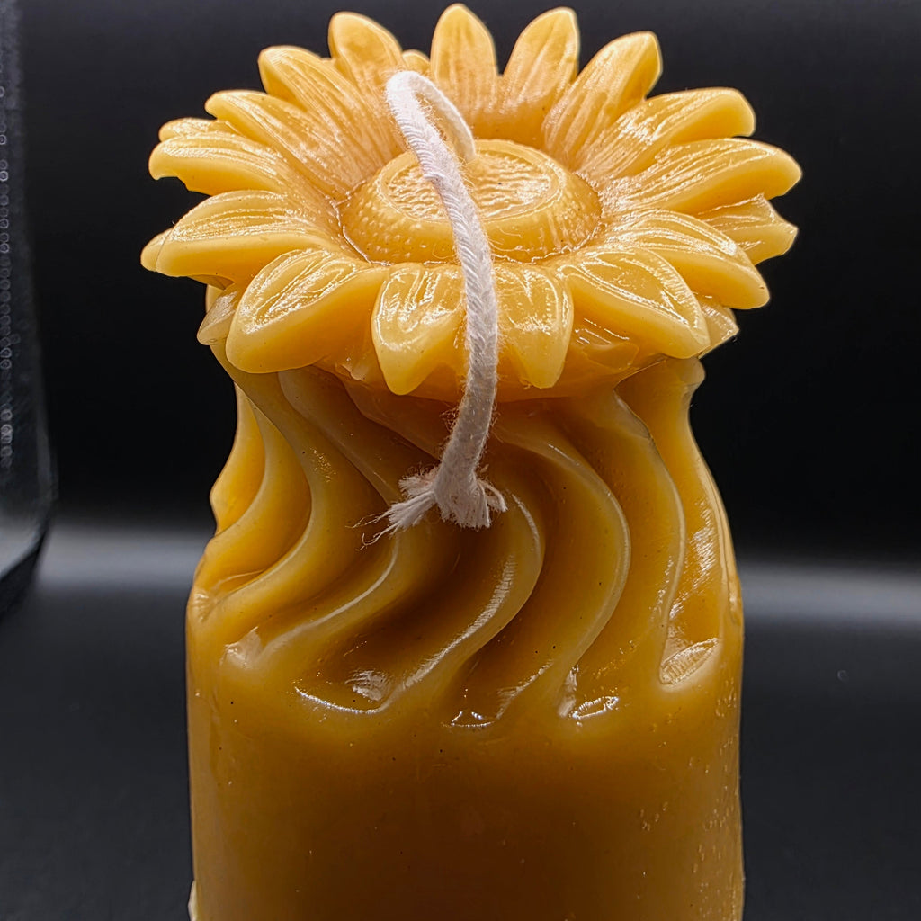 Sunflower candle design on a dark background