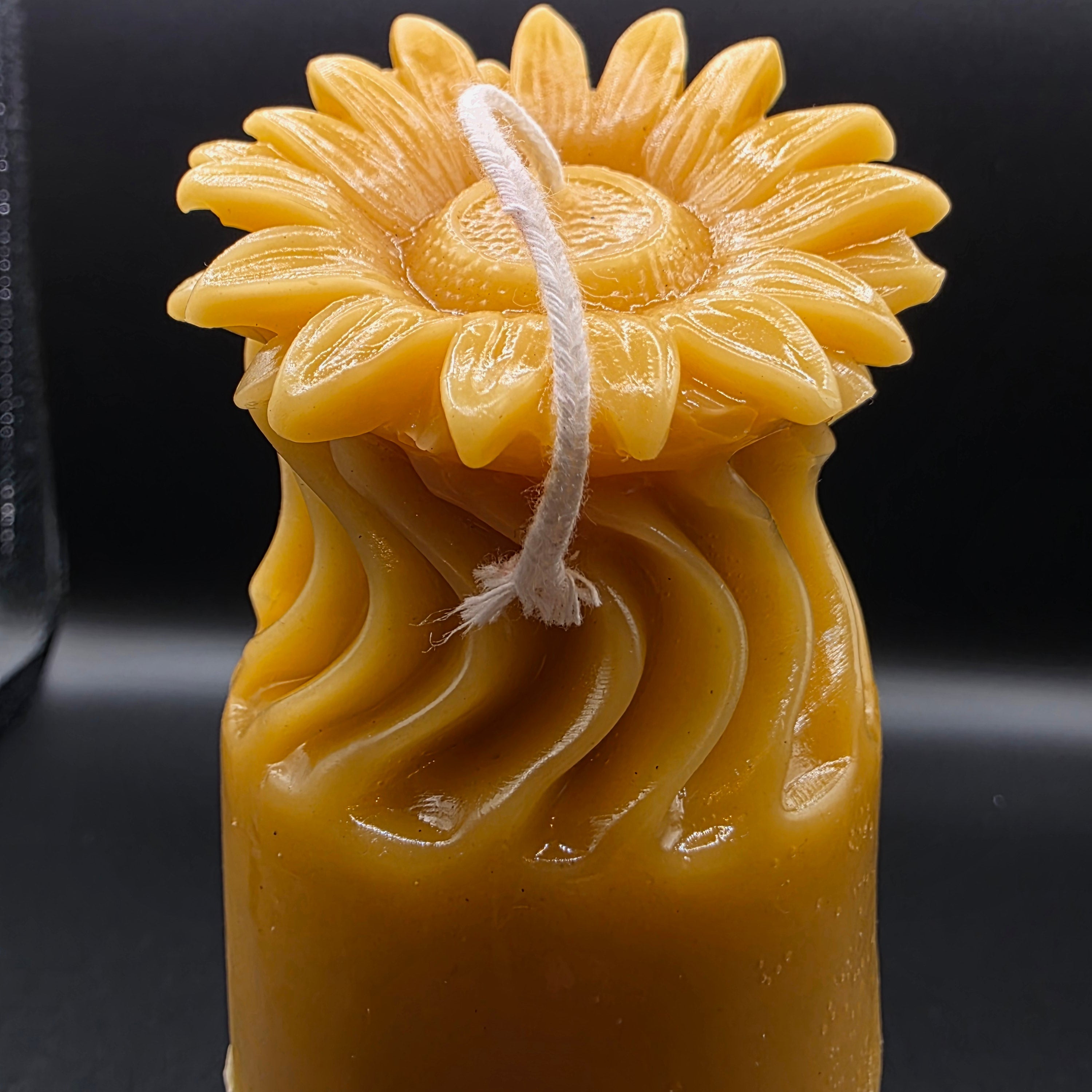 Sunflower candle design on a dark background